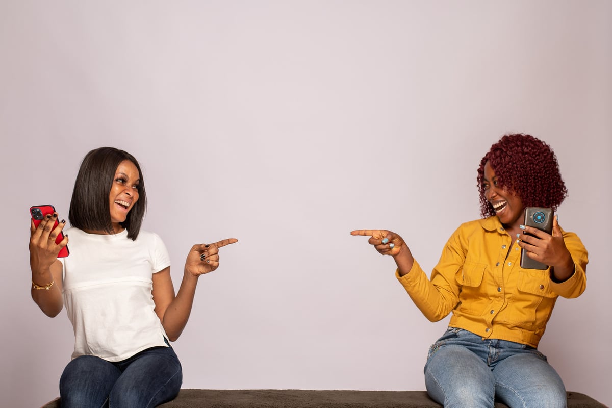 excited young black women with their phones